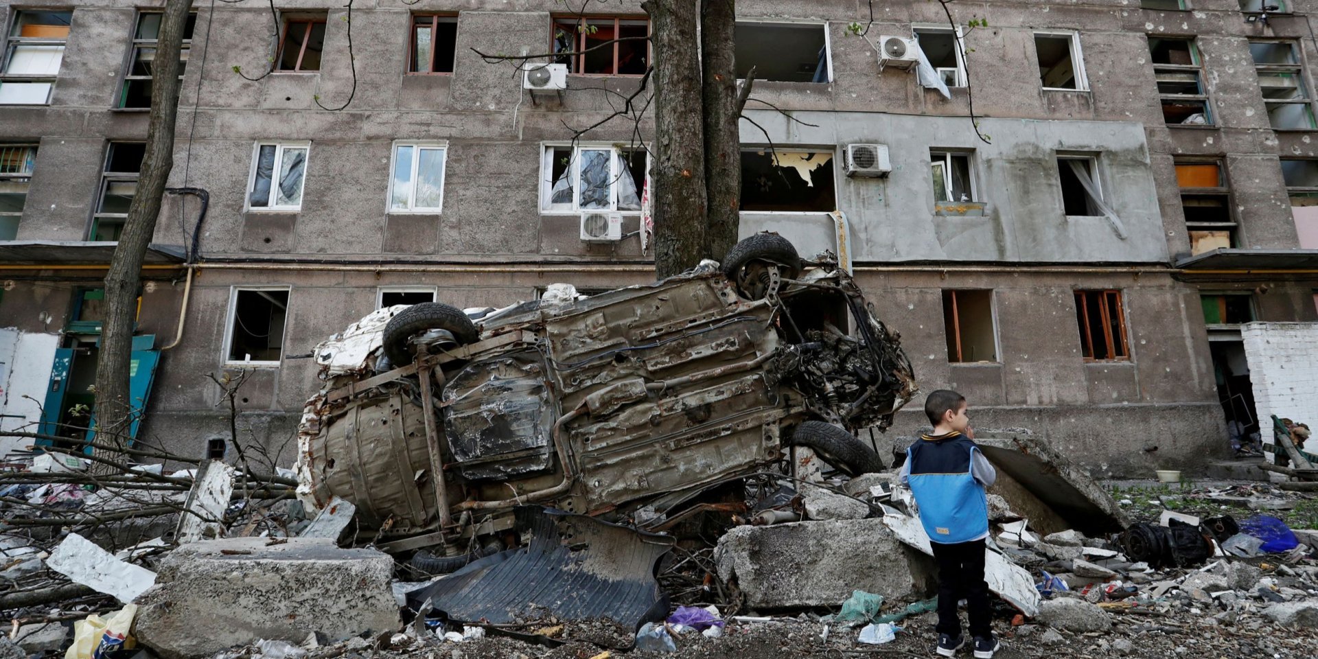 A boy stands near a building in Mariupol, destroyed by Russian shelling (Photo: REUTERS/Alexander Ermochenko)