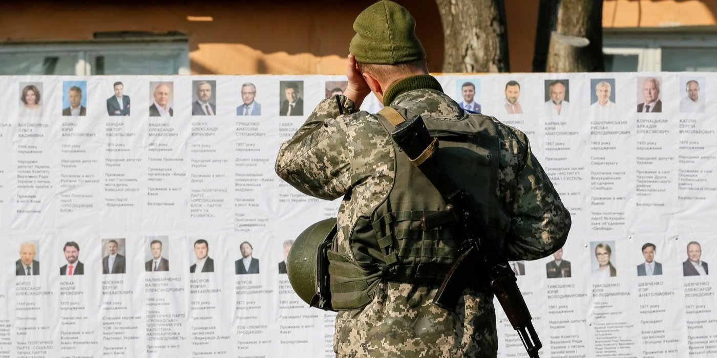 Український військовослужбовець читає інформацію про кандидатів у&nbsp;президенти на&nbsp;виборчій дільниці поблизу лінії фронту, під час президентських виборів у&nbsp;селі Зайцеве, 31 березня 2019 рік (Фото: REUTERS/Gleb Garanich)