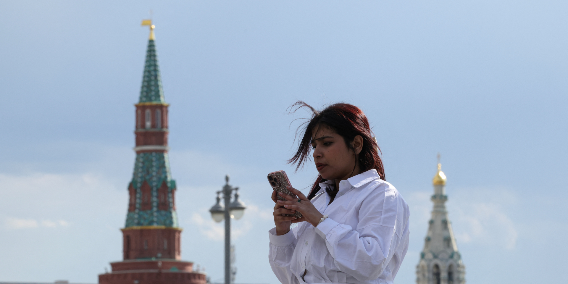 Жінка дивиться у&nbsp;свій мобільний телефон у&nbsp;центрі Москви, 4 травня 2026 року (Фото: REUTERS/Ramil Sitdikov)