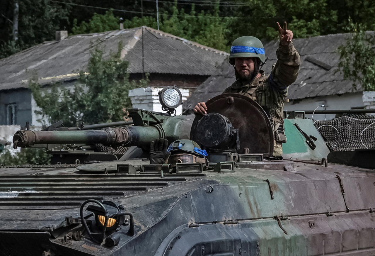 ДО БОЮ ГОТОВИЙ: Військово­службовець ЗСУ вітає репортерів із бойової машини піхоти в Сумській області неподалік кордону з Росією (Фото: Viacheslav Ratynskyi / Reuters)