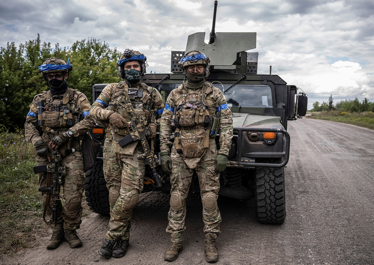 ДОРОГОЮ НА ПІВНІЧ:  Українські бійці позують на фоні військової машини в Сумській області неподалік кордону з Росією (Фото: Viacheslav Ratynskyi / Reuters)
