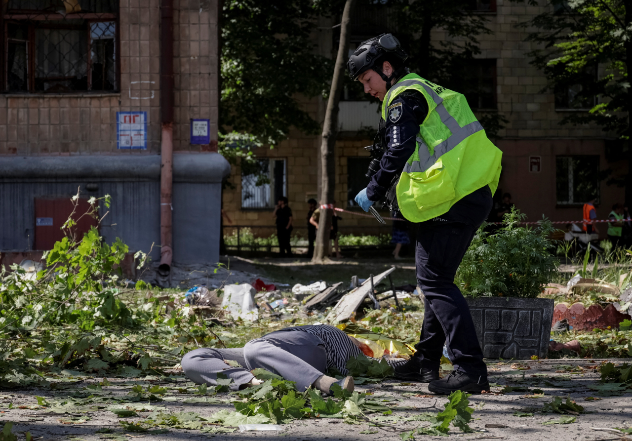 Росія регулярно вчиняє воєнні злочини щодо України: катування, вбивства мирних жителів, обстріли населених пунктів, захоплення цивільних та незаконна депортація дітей. Фото: наслідки ракетної атаки по Харкову, липень, 2026 рік (Фото: REUTERS/Sofiia Gatilova)